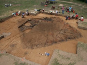 Archaeological team excavating a structure.